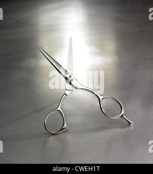 A Pair of Scissors open, with blades facing upwards on brushed aluminium background Stock Photo