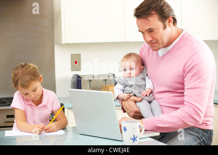 Father with children using laptop in kitchen Stock Photo