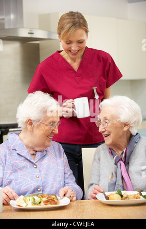 Senior women with carer enjoying meal at home Stock Photo