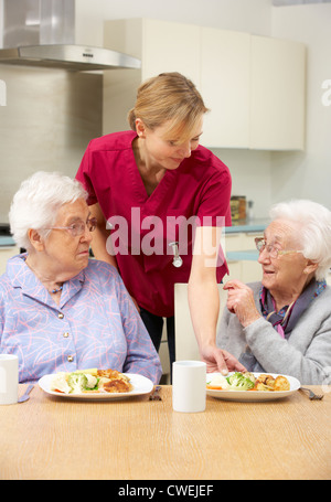 Senior women with carer enjoying meal at home Stock Photo