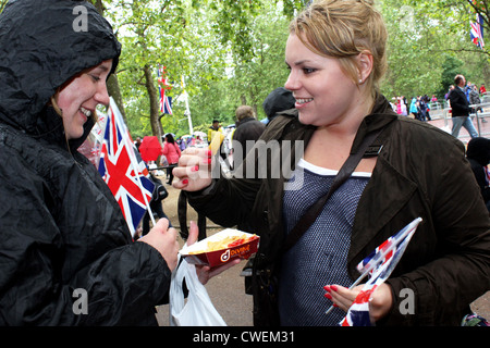 Two young women eating fish and chips on The Mall. Celebrations at the Queen's Diamond Jubilee London, 2012 Stock Photo