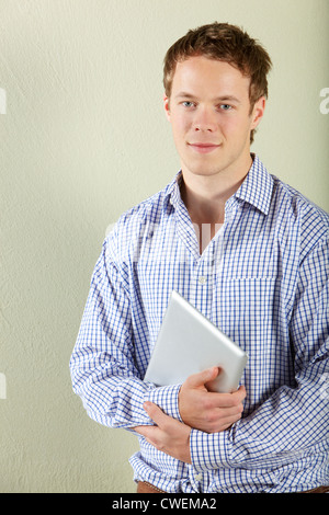 Studio Shot Of Young Man Holding Tablet Computer Stock Photo