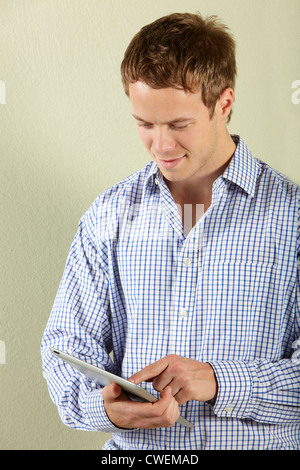 Studio Shot Of Young Man Using Tablet Computer Stock Photo