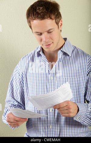 Studio Shot Of Young Man Looking at Bills Stock Photo