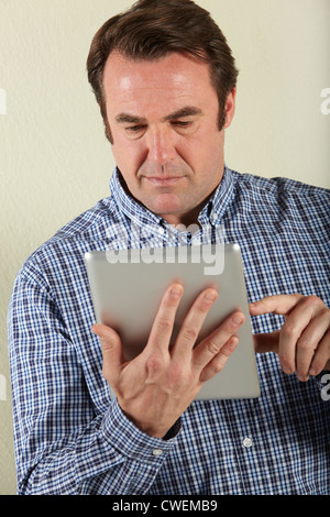 Studio Shot Of Middle Aged Man Using Tablet Computer Stock Photo