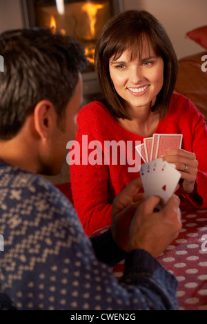 Couple Playing Cards By Cosy Log Fire Stock Photo
