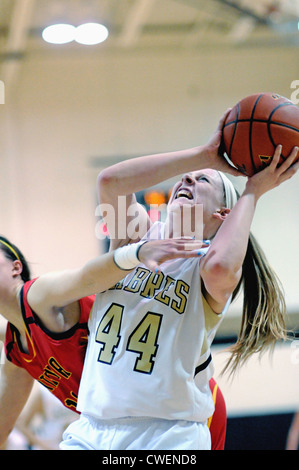 Basketball player struggles in the paint with opponent as she tries to put away a put pack shot off an offensive rebound. USA. Stock Photo