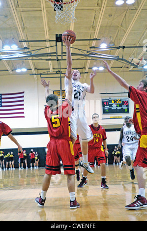 Basketball player shoots over blocking opponent Stock Photo