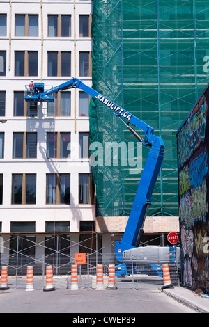 Construction workers on aerial lift working on steel beam framework ...