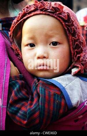 Nepali Newar little baby in a red hood. Close-up. Bhaktapur, Kathmandu Valley, Nepal Stock Photo