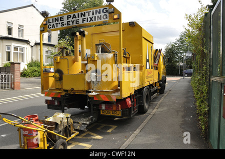 Yellow line painting vehicle with fire going on truck bed to heat material Stock Photo