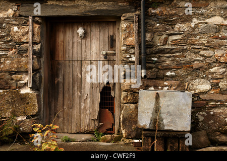 Old barn door on an farm building decorated with a sheep skull in rural North Wales Stock Photo