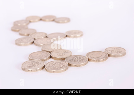 Pound symbol made from gold pound coins on a white background with shallow depth of field. Stock Photo