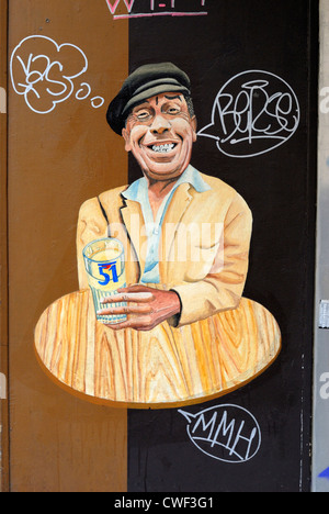 Paris, France. Mural on outside wall of cafe in Rue Nicolet (18th Arr) Man sitting at table with glass Stock Photo
