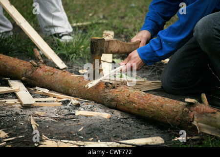Old Axe stuck in a chopping block and splinters of wood with natural background man Stock Photo