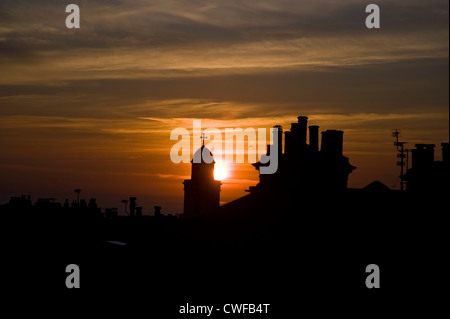 Sunset with lone seagull behind church spire,with rooftops and chimneys, Brighton, UK Stock Photo