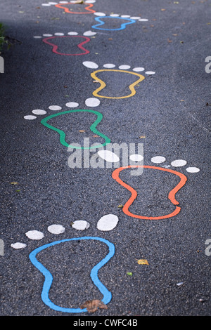 Coloured footprints leading into a school playground. Stock Photo