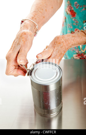 Senior woman's hands with arthritis, struggling to open a can.  Stock Photo