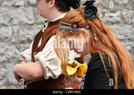 Young woman with long red hair in medieval gipsy costume many golden earrings headdress historic Staufer town Bad Wimpfen Germany Stock Photo