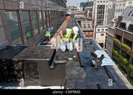 Roofing contractors working on a roof in the City of London. Stock Photo