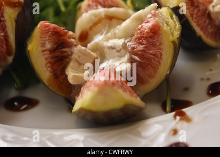 Baked figs with goat cheese walnuts on rocket salad Stock Photo