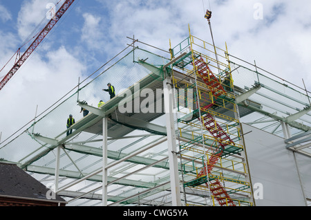 Workman laying insulation panels on roof Stock Photo