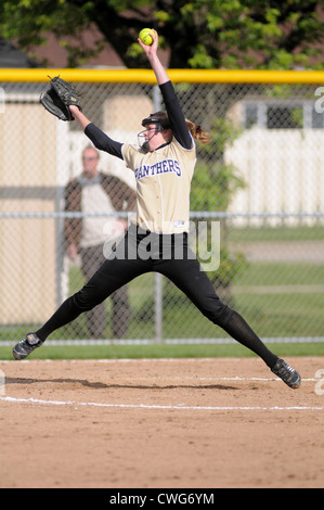 Softball Pitcher throws ball high school game. Stock Photo