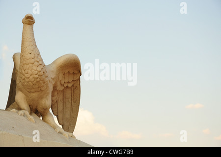 Statue fragment on an entrance in the Odessa opera theater - a bird the Phoenix, against the blue sky. Stock Photo