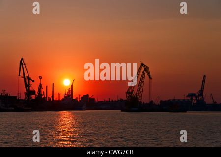 Evening sea port, cargo cranes against the setting sun. Odessa. Ukraine. Stock Photo