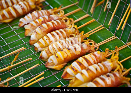 Grilled squids sold on the street asian market Stock Photo