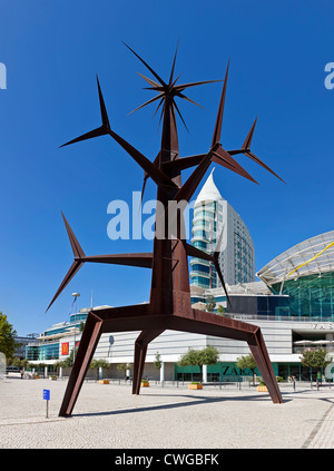 Homem-Sol (Sun Man) Sculpture. Vasco da Gama Shopping and São Gabriel Tower in the back. Parque das Nações in Lisbon, Portugal. Stock Photo