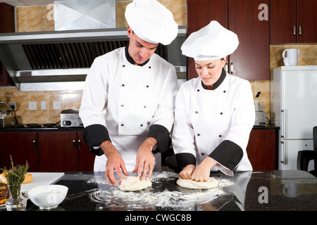 chefs making dough in kitchen Stock Photo