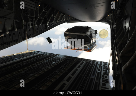 A boat flies out of the back of a C-17 Globemaster III April 9, 2012, over the ocean surrounding Naval Base Guam during a training mission. During the mission, the aircrew dropped static-line personnel, heavy equipment platforms, high-velocity container delivery system bundles, low-velocity CDS bundles, and high-altitude low-opening jumpers during their time in Guam. Stock Photo