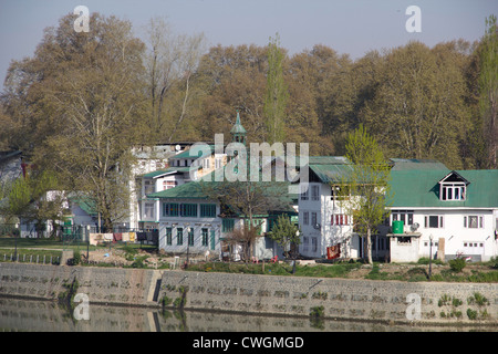 Buildings on the shore of section of Dal Lake in Srinagar. This place looks beautiful, with these houses and trees. Stock Photo