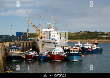 The Scillonian III off loads cargo at the Quay in Hugh Town harbor, St Mary's, Isle of Scilly. Off island ferries wait alongside Stock Photo