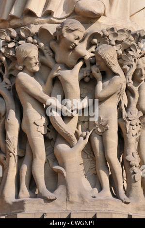 Paris, France. Notre Dame cathedral - facade detail. Adam, Eve eating the forbidden fruit, and the serpent in woman's form Stock Photo