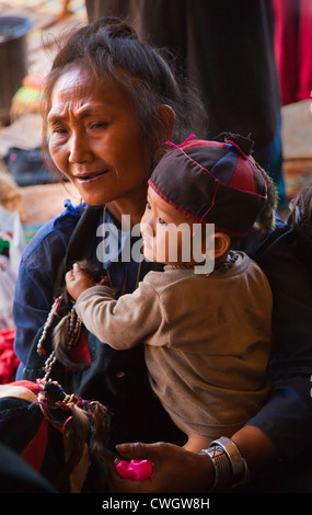 A ANN TRIBAL woman with her GRANDSON in traditional dress in her village near KENGTUNG also known as KYAINGTONG - MYANMAR Stock Photo