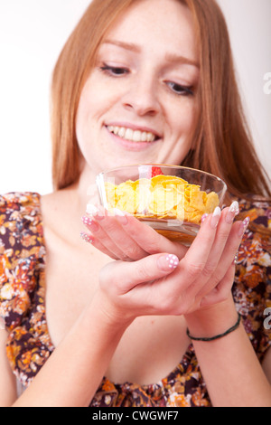 Beautiful young woman eating cereals with strawberries. Stock Photo