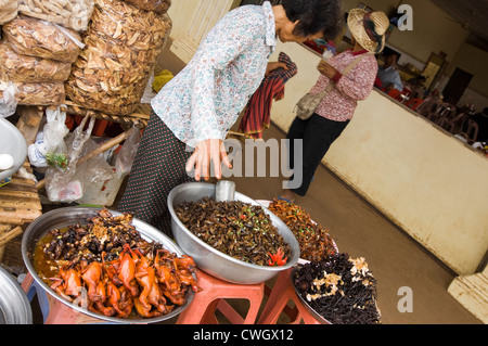 Horizontal wide angle view of a typical roadside market selling strange deep fried insects and whole small birds in Cambodia Stock Photo