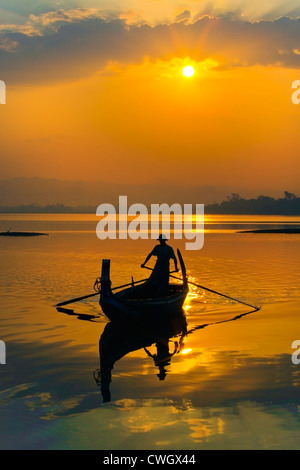 FISHERMAN ply the waters of Taungthaman Lake at sunrise - AMARAPURA, MYANMAR Stock Photo