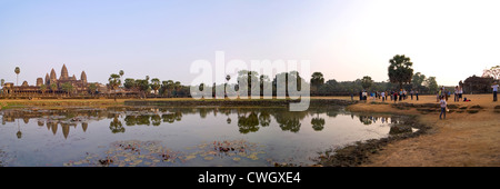 Horizontal panoramic (2 picture stitch) view of the amazing architecture at Prasat Angkor Wat reflected in the water at sunrise. Stock Photo