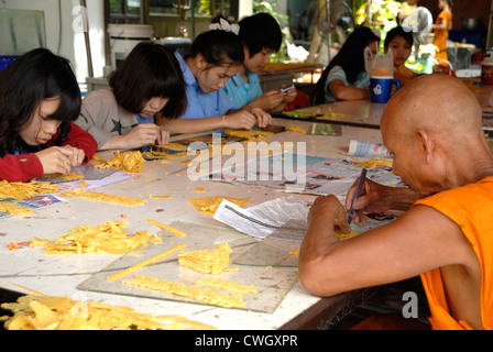 Monk and school children carving with wax on 1/08/2012 at the Candle and wax festival (Khao Phansa) in Ubon ratchathani Northeas Stock Photo