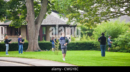 Pipers from a pipe band warm up and tune their bagpipes on a lawn prior to a group practice/rehearsal. Stock Photo