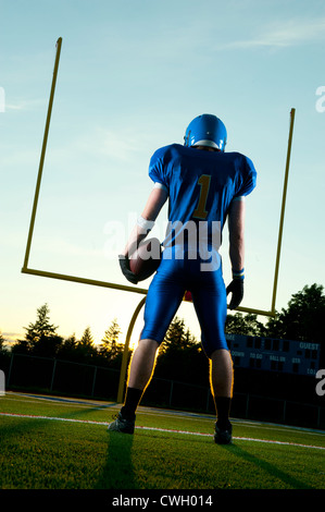 Caucasian football player standing with football Stock Photo