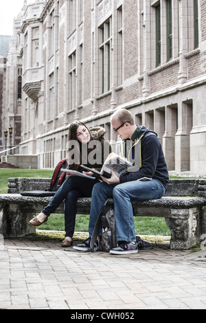 Students sitting on bench together Stock Photo