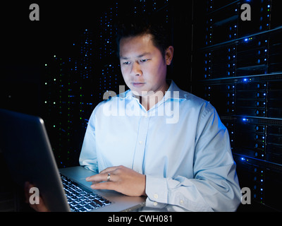 Asian businessman working in server room Stock Photo