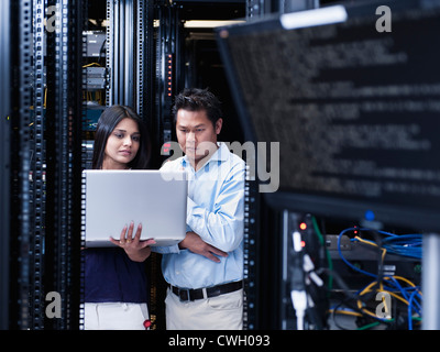Indian business people using laptop in server room Stock Photo