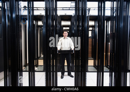 Asian businessman standing in empty server room Stock Photo