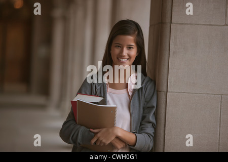 Smiling mixed race student on campus Stock Photo