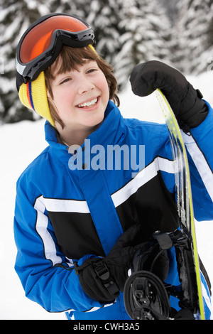 Young Boy With Snowboard On Ski Holiday In Mountains Stock Photo